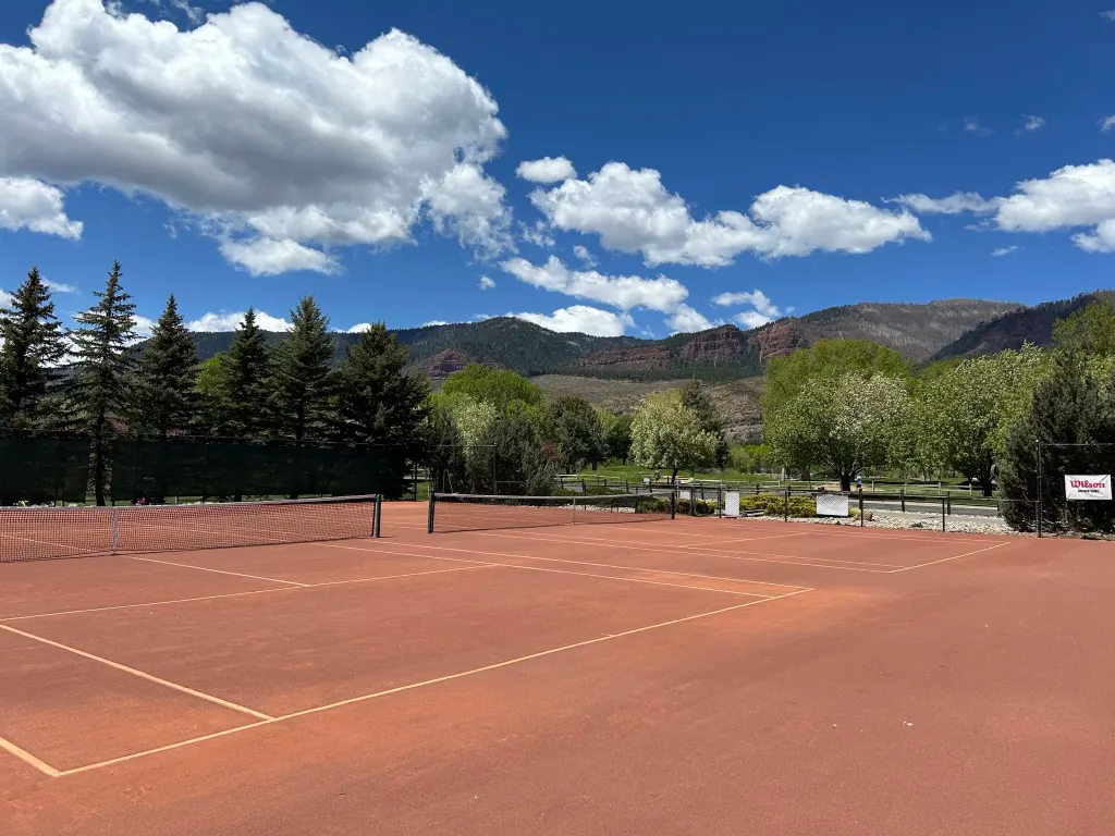 Dalton Ranch clay tennis courts with Colorado mountain backdrop and blue sky