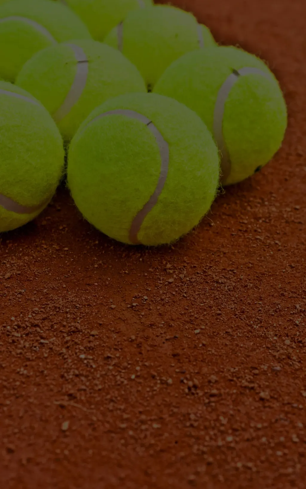 Tennis balls on a clay court — illustrative for rotating destination camps
